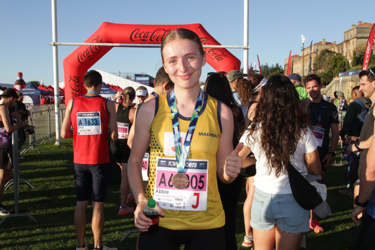 Madibaz Athletics runner Abbie Mitchell celebrates her gold medal in the junior category at the Two Oceans Half-Marathon in Cape Town.