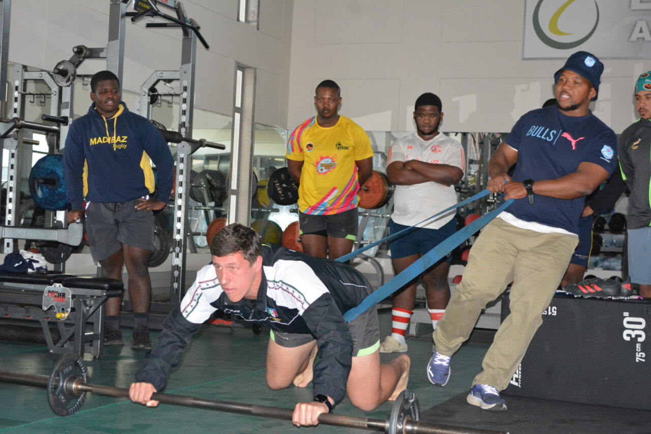 Blue Bulls U21 head coach Edgar Maratlulle, right, goes through some drills in the gym with Madibaz rugby players during a coaching workshop.